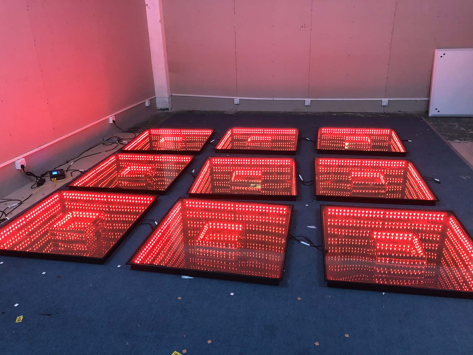 An indoor event scene with an LK - CH01 Rainbow dance floor showcasing a solid - color lighting effect in red, creating a vibrant atmosphere.