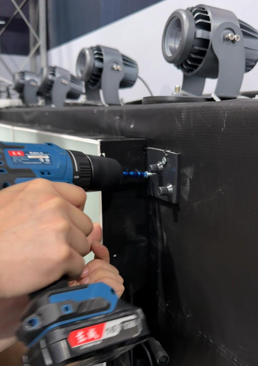 Professional installation of customized LED dance floor panels using wall drilling for vertical mounting.