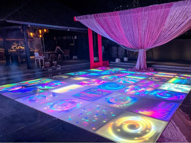Piste de danse LED multicolore avec motifs tourbillonnants de galaxie, attirant l’attention lors d’une soirée privée.