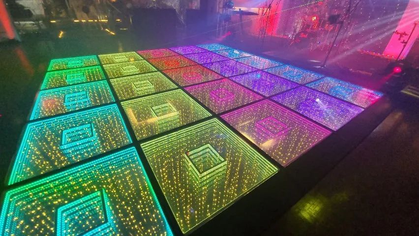 Piste de danse LED 3D double à miroir infini imbriqué, colorée, illuminée lors d’un événement festif.