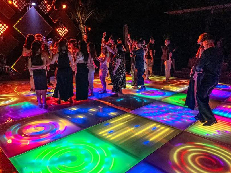 Piste de danse LED colorée personnalisée avec effets lumineux en spirale lors d’un événement d’entreprise en extérieur.