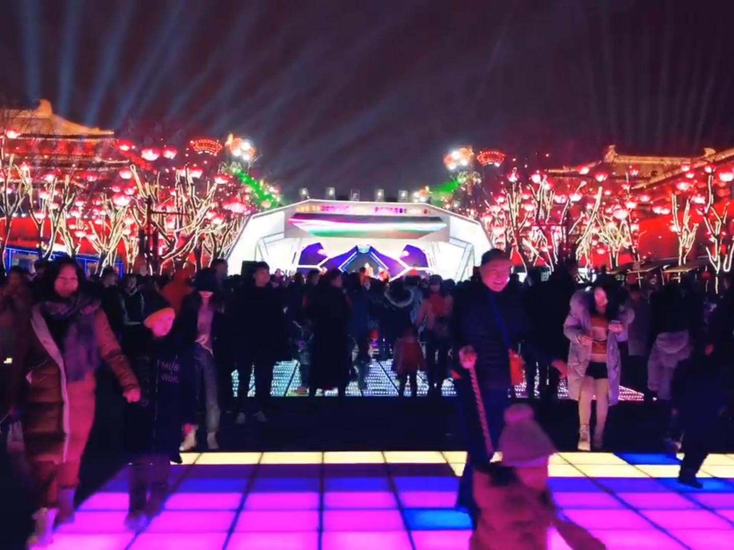 Piste de danse LED colorée de grande surface utilisée lors d’un projet d’éclairage de festival en extérieur avec lanternes décoratives.