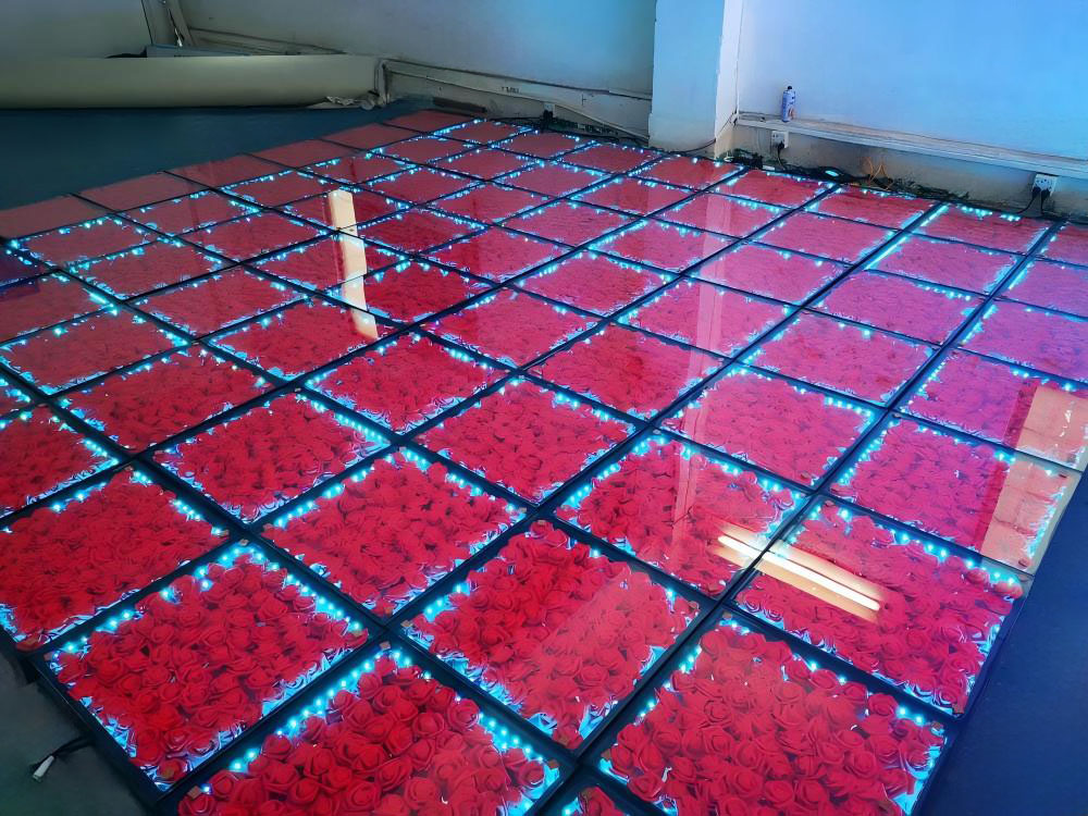 Piste de danse LED florale avec roses rouges et coque ABS, éclairage périmétrique bleu en test en studio.