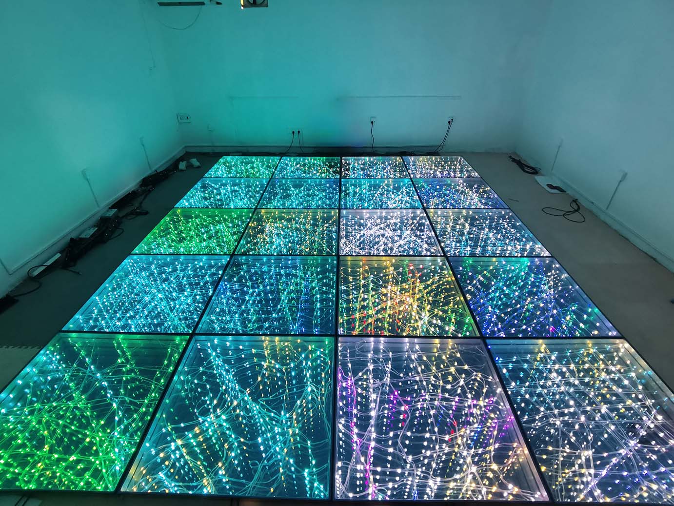 A full-color starlit dance floor displaying multi-color pixel lighting effects in a factory showroom.