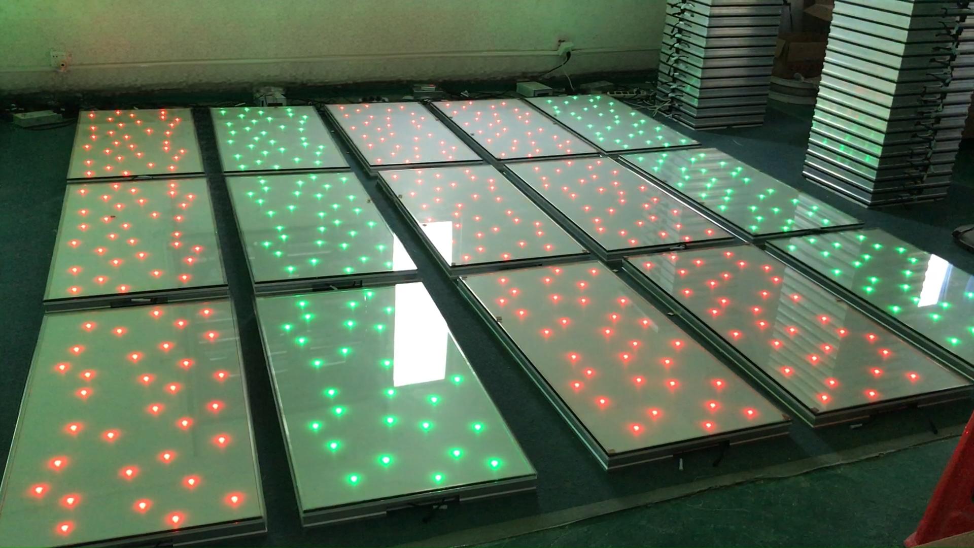 Custom rectangular white LED starlit dance floor panels with red and green lights in a factory.