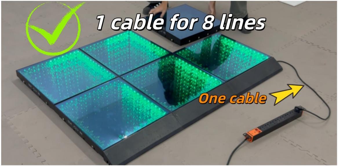 Green glowing 3D LED dance floor panels connected with a single power cable to a socket.
